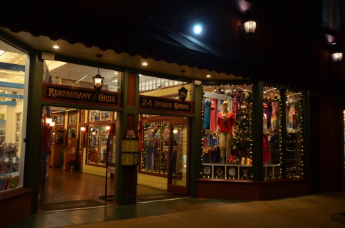 A brightly lit restaurant and grill entrance, decorated with colorful displays and festive lights at night.