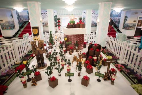 A festive display featuring a gingerbread village with nutcracker figures, trees, and holiday decorations.