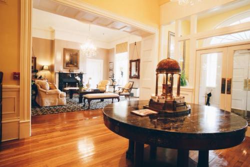 Elegant living room with a round table, plush seating, and a warm color palette, featuring chandeliers and a fireplace.