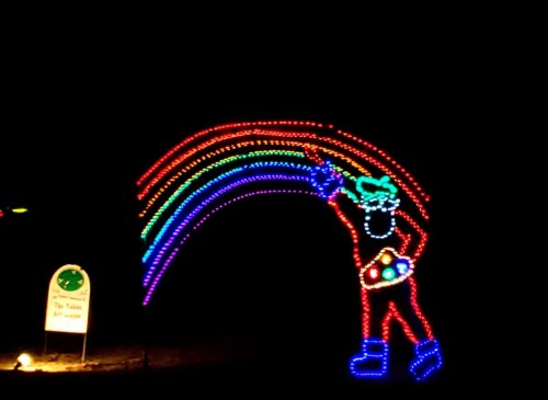 A colorful light display of a clown holding a paint palette, creating a rainbow against a dark background.