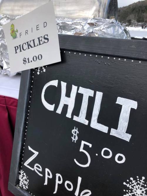 Sign displaying food items: "Fried Pickles $1.00," "Chili $5.00," and "Zeppole."