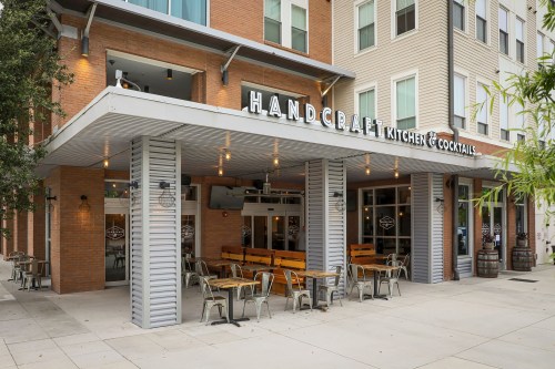 Exterior view of Handcraft Kitchen & Cocktails, featuring outdoor seating and a modern building design.