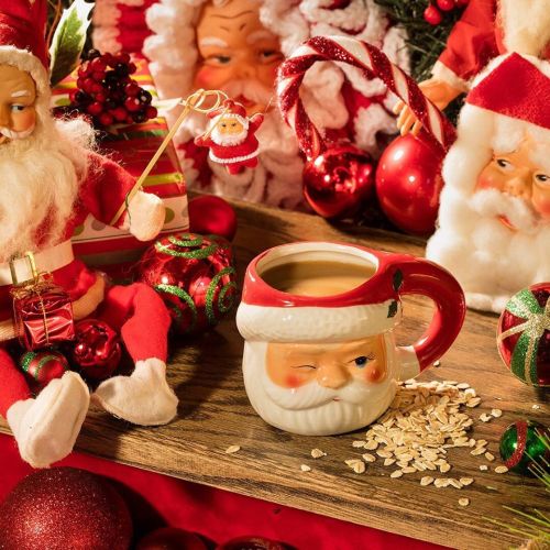 A festive display featuring Santa figurines, Christmas ornaments, a mug with a Santa face, and scattered oats.
