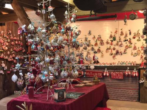 A festive display featuring a decorated tree and walls adorned with various Christmas ornaments and decorations.