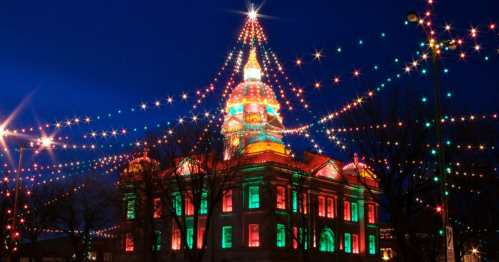 A beautifully lit building adorned with colorful Christmas lights against a night sky.