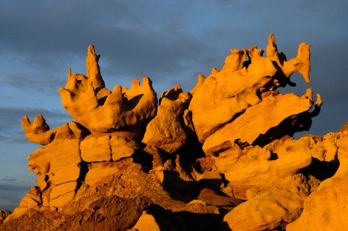 Unique rock formations illuminated by golden sunlight against a dramatic sky.