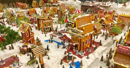 A festive gingerbread village with colorful houses, snowy paths, and decorative trees, creating a whimsical holiday scene.
