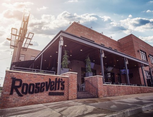 Exterior view of Roosevelt's Gastropub, featuring a brick facade and outdoor seating under a cloudy sky.