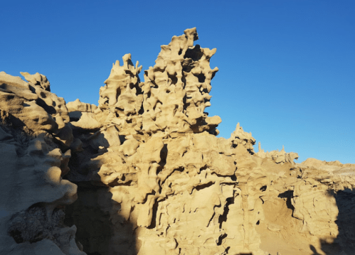 Rock formations with intricate textures against a clear blue sky.