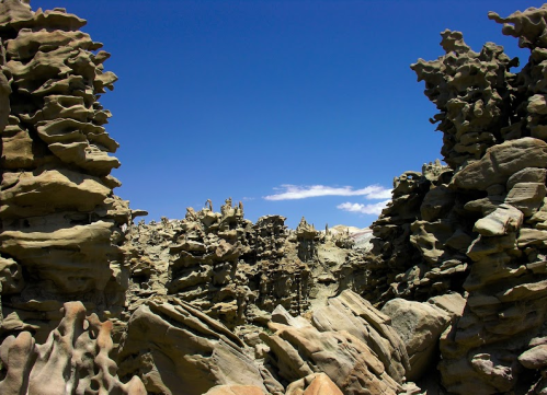Unique rock formations rise against a clear blue sky, creating a surreal landscape of natural sculptures.