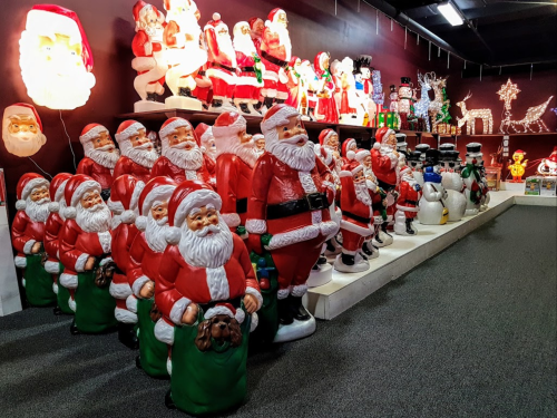 A festive display of numerous Santa Claus figures and holiday decorations in a store.