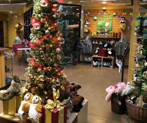 A festive store interior featuring a decorated Christmas tree, plush toys, and holiday decorations.