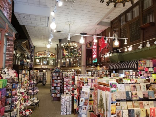 A vibrant store interior filled with greeting cards, gifts, and colorful displays under bright lights.