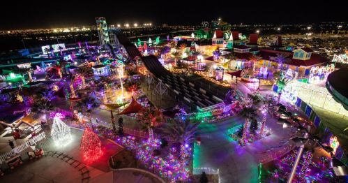 A vibrant amusement park illuminated with colorful lights at night, featuring rides and festive decorations.