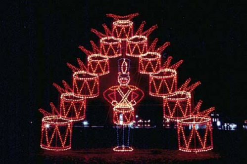 A festive display of lights featuring a toy soldier and stacked drums, creating a cheerful holiday scene.