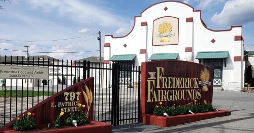 Entrance to the Frederick Fairgrounds, featuring a large sign and a building with a decorative wheat motif.
