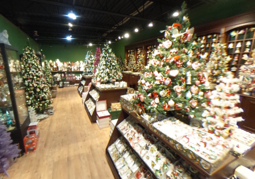 A festive shop filled with decorated Christmas trees and holiday ornaments, creating a cheerful atmosphere.