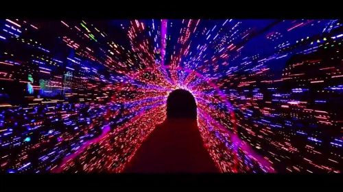 A vibrant tunnel of colorful lights, creating a dynamic, swirling effect that suggests movement and depth.