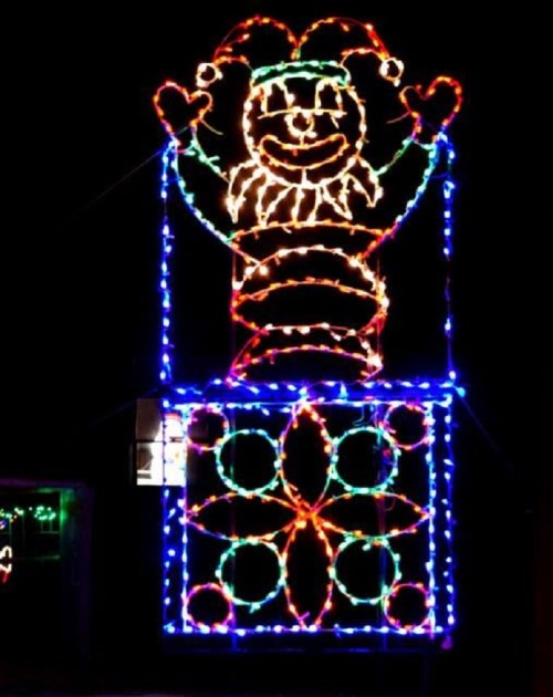 Colorful holiday lights form a jester figure with arms raised, set against a dark background.