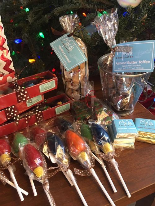 A festive display of colorful candies, toffee, and treats, arranged with holiday decorations in the background.