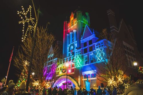 A brightly lit building adorned with colorful lights and festive decorations during a nighttime holiday event.
