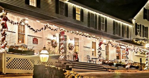 A beautifully decorated building with festive lights and garlands, creating a warm holiday atmosphere at night.