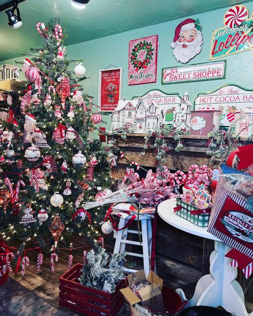 A festive room decorated for Christmas with a tree, candy-themed decor, and a hot cocoa bar.