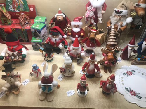 A festive display of wooden holiday figurines, including Santa, reindeer, snowmen, and various animals in Christmas attire.