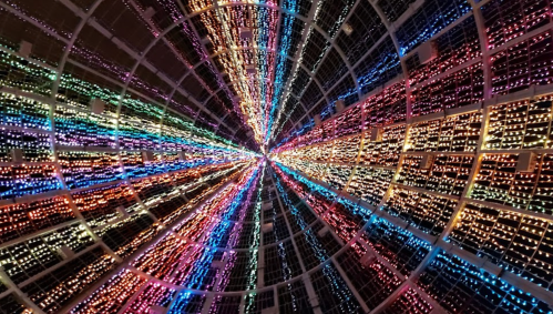 A vibrant display of colorful lights radiating outward in a circular pattern, creating a mesmerizing tunnel effect.