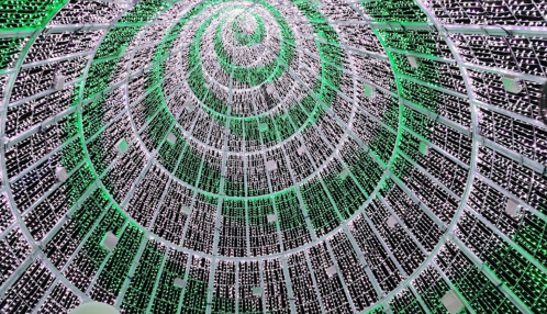 A spiral pattern of lights and structures, creating a mesmerizing, futuristic design from a low angle perspective.