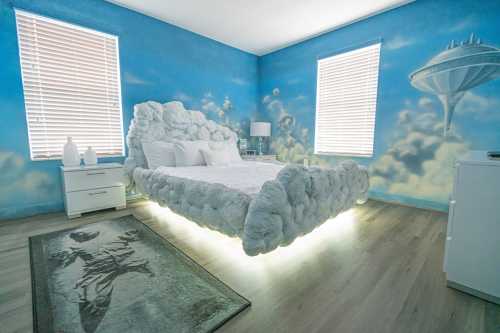 A whimsical bedroom with cloud-shaped bed, blue sky mural, and modern decor, featuring soft lighting and a space-themed rug.