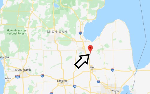 Map of Michigan highlighting Flint with a red marker and an arrow pointing to its location.