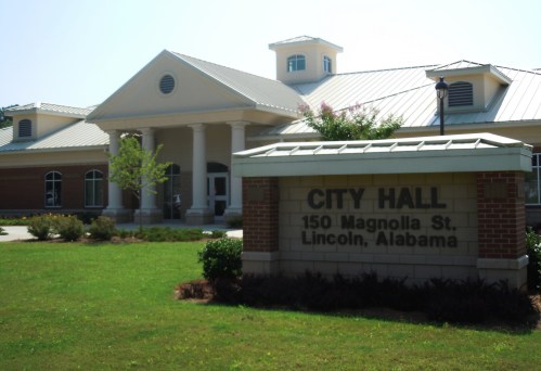 City Hall building in Lincoln, Alabama, featuring a brick facade and landscaped lawn.