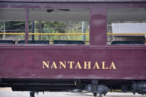 A close-up of a maroon train car with the word "NANTAHALA" displayed prominently on the side.