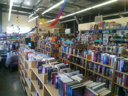 A cozy bookstore interior with shelves filled with books, colorful decorations, and customers browsing.