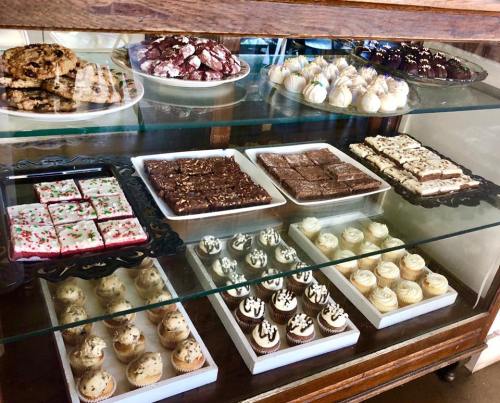 A display case filled with various baked goods, including cookies, brownies, and cupcakes, beautifully arranged.