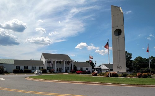 Exterior view of the Jacksonville Museum of Military History, featuring a tall monument and flags under a blue sky.