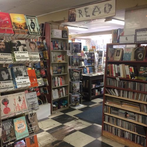 A cozy bookstore interior with shelves of books and CDs, inviting readers to explore and discover new titles.
