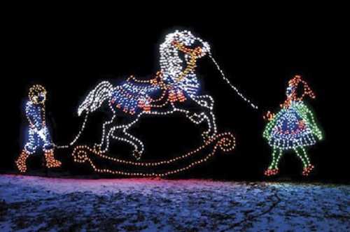 A colorful light display featuring a horse on a rocking base, with a child and a figure holding its reins.