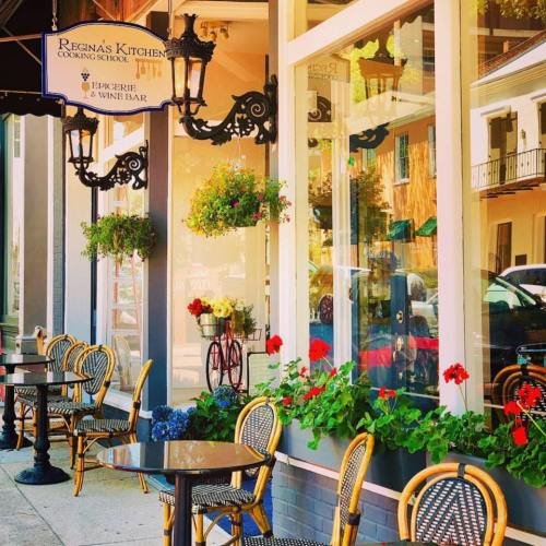Charming outdoor seating at Regina's Kitchen, featuring flowers and decorative lanterns in a vibrant setting.