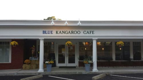 Exterior of Blue Kangaroo Cafe, featuring a welcoming entrance with flower pots and a sign above the door.
