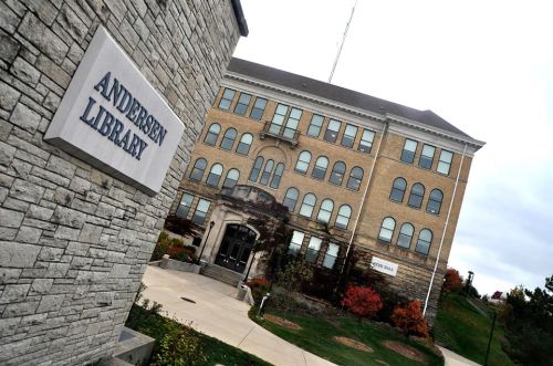 Exterior view of Andersen Library, featuring a stone facade and a large, historic building with colorful landscaping.