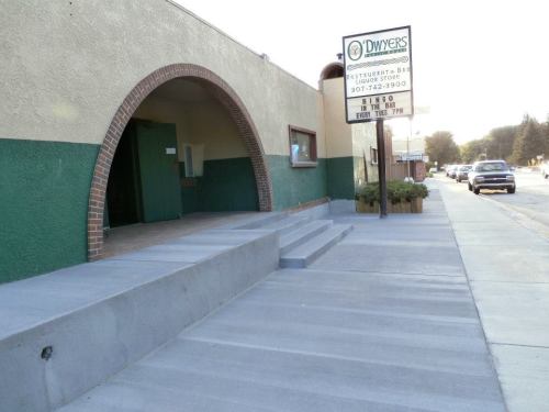Exterior view of Dwyer's restaurant and bar, featuring a curved entrance and a sign with event details.