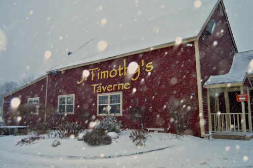 A red building with "Timothy's Taverne" sign, surrounded by snowflakes in a winter scene.