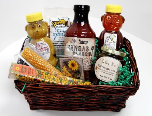A gift basket filled with honey, BBQ sauce, sunflower seeds, and snacks, all arranged with green filler.
