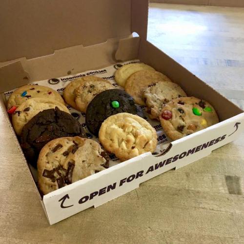 A box of assorted cookies, including chocolate chip, M&M, and other varieties, labeled "OPEN FOR AWESOMENESS."