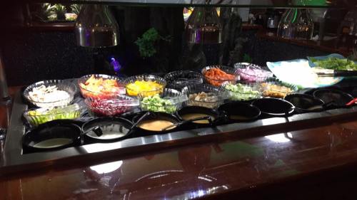 A vibrant salad bar featuring a variety of fresh vegetables, toppings, and dressings in clear bowls.