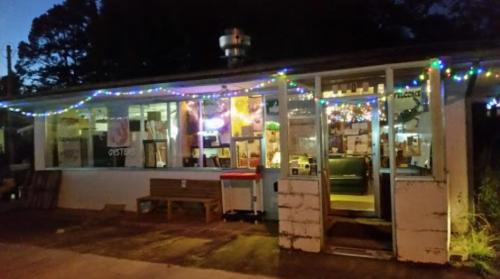 A cozy restaurant exterior adorned with colorful lights, featuring large windows and a welcoming entrance.