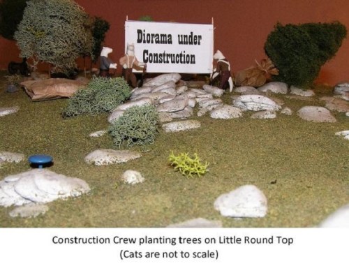 A miniature diorama shows a construction crew planting trees, with a sign reading "Diorama under Construction."