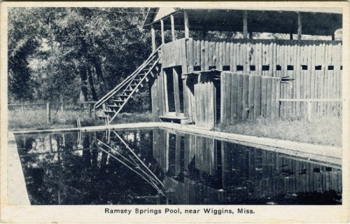 Black and white photo of Ramsey Springs Pool near Wiggins, Mississippi, featuring a wooden structure and reflecting water.